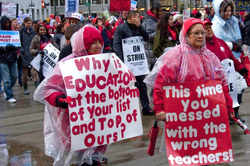 Teachers holding posters in protest- teachers poverty