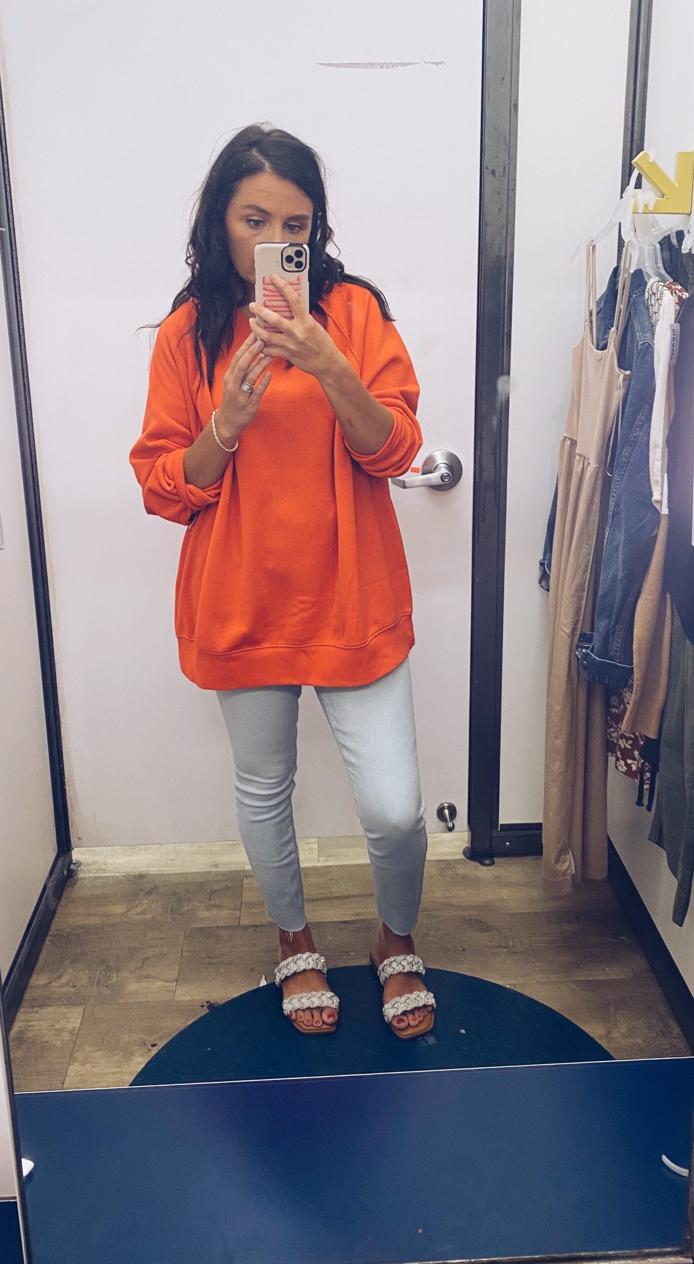 Woman wearing orange sweatshirt and jeans