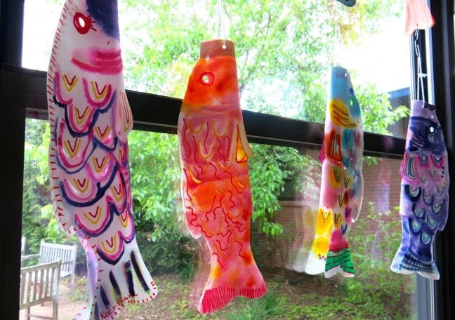 Colorful fish-shaped kites hanging in a window
