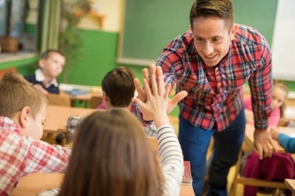 Teacher giving a student a high-five.
