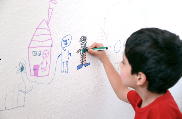 Child writing on walls in classroom