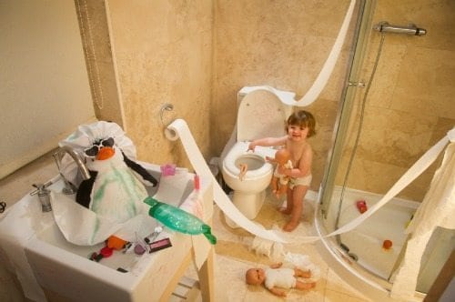 Kids in messy bathroom covered with toilet paper and soap.