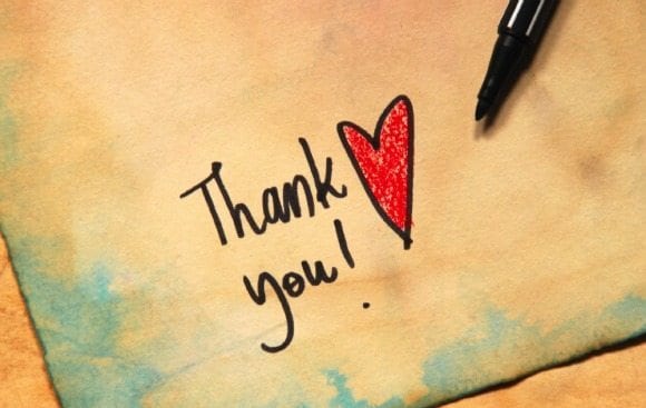 handwritten "thank you" with a heart on a piece of paper