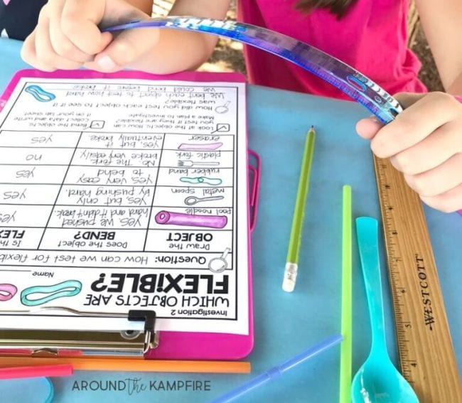 Child's hands bending a blue plastic ruler