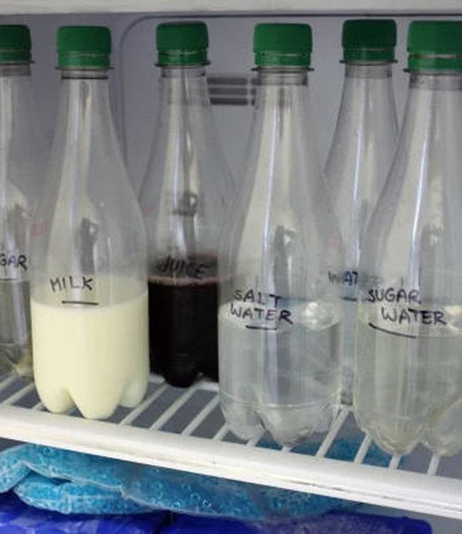 Clear bottles on a freezer shelf labeled milk, juice, salt water, water, and sugar water (2nd Grade Science)