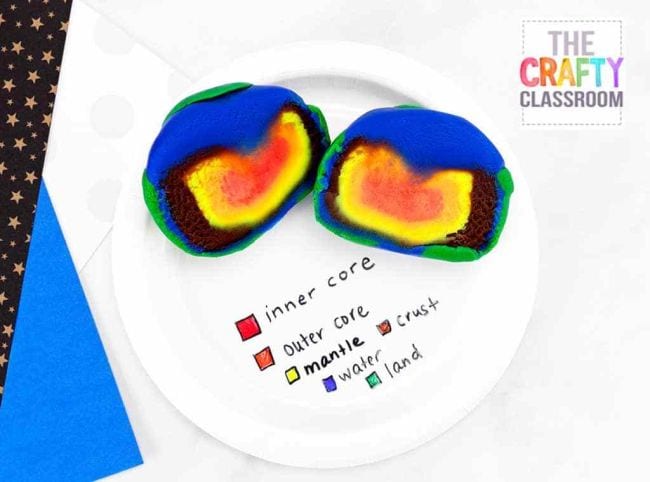 Play-Doh model of the earth cut in half to show a red core, yellow mantle, and brown crust