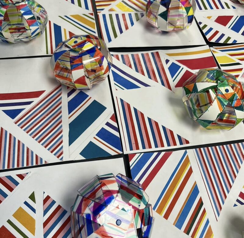 Clear 3-D cubes mounted on colorful geometric patterns