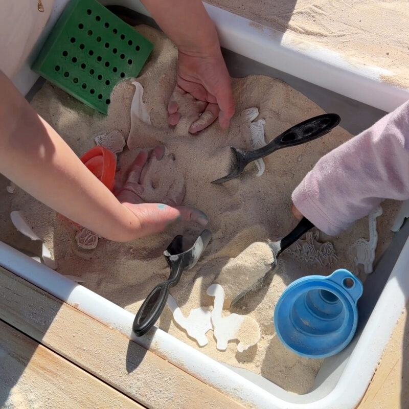Kids digging in a sand bin for 3D printed dinosaur "fossils"