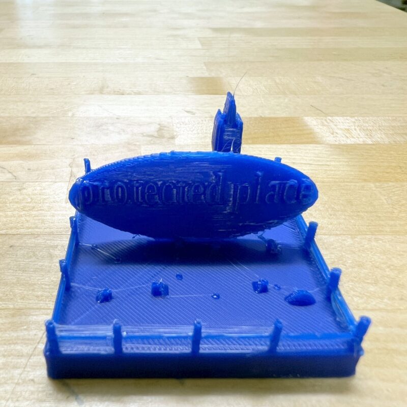 3D printed "protected area" model with a fence and large sign