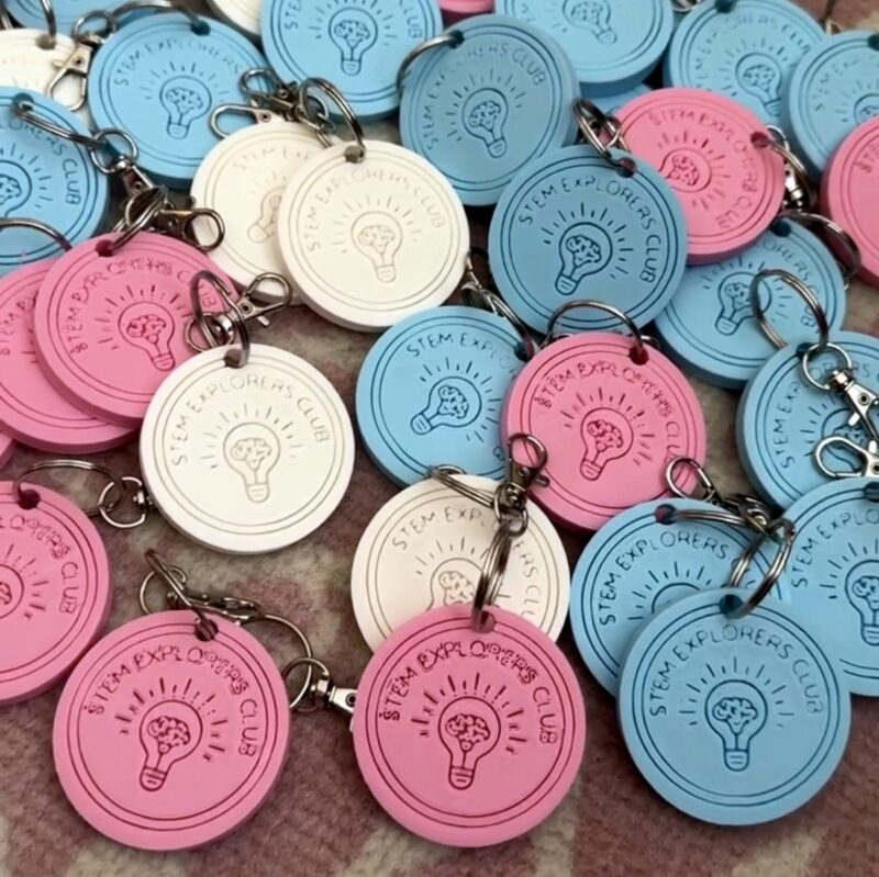 3D printed keychains in pink, blue, and white