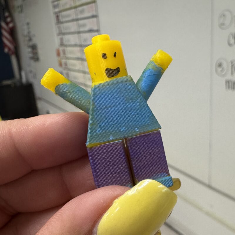 Woman's hand holding a 3D printed LEGO-style minifigure