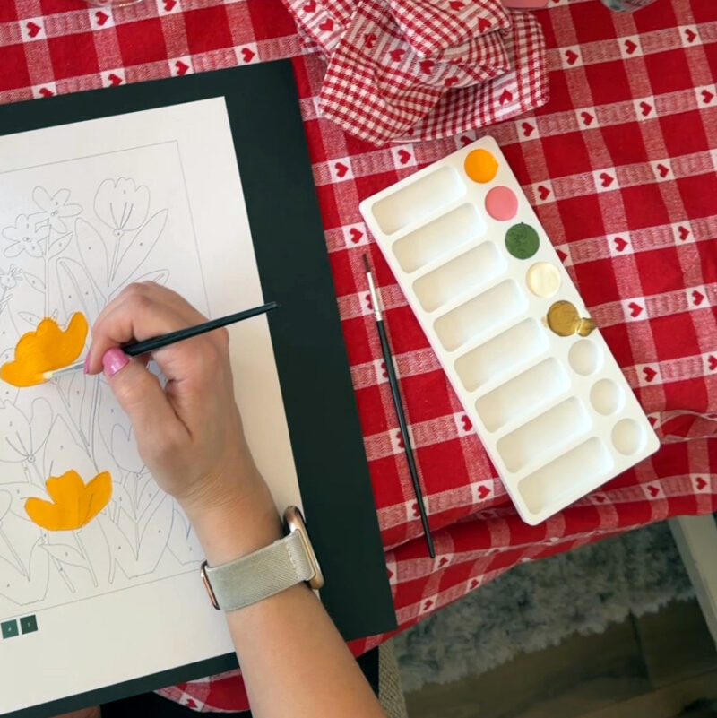 Woman painting a picture using a 3D printed paint palette