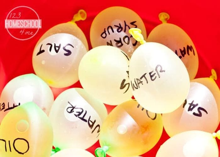 Water balloons labeled with items like salt and sugar in a big red bin