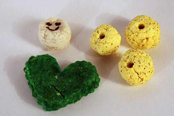Green plastic heart and yellow beads made from milk caseins