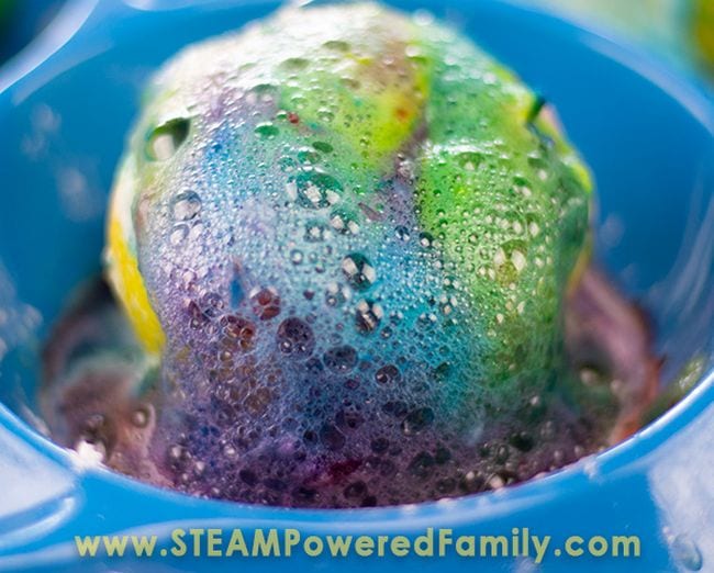 Cut lemon in a blue bowl covered in colorful fizzy foam