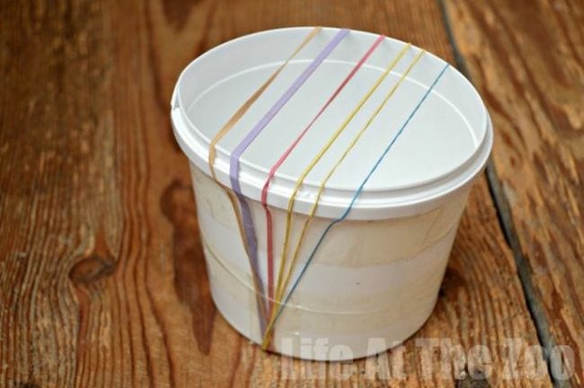 White plastic cup with rubber bands stretched across the opening (Easy Science Experiments)