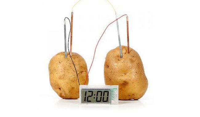 Two potatoes with electrical wires running from them to a small digital clock