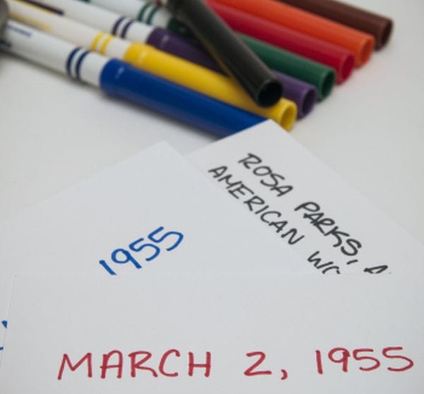 Colorful markers next to note cards with historical names and dates