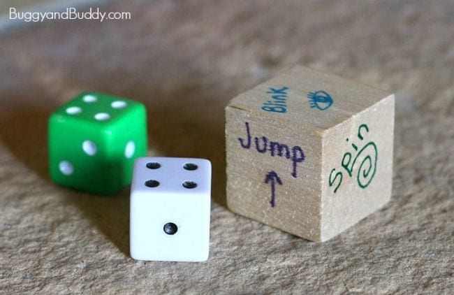 Pair of dice with a wooden die with sides labeled jump, spin, and other activities (Active Math Games)