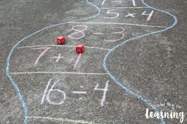 Curved path drawn on the sidewalk with math problems and a pair of dice