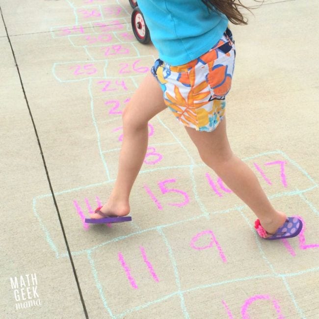 Student playing hopscotch on the sidewalk