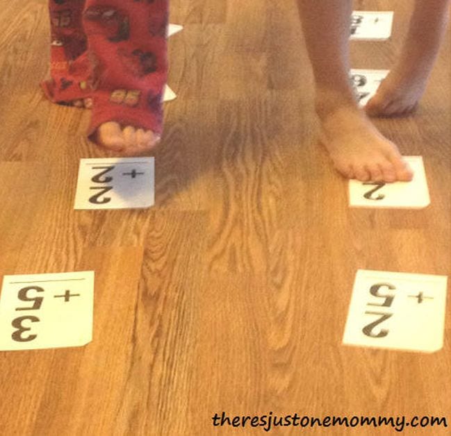Children walk along a line of flashcards on the floor