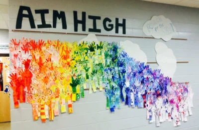Aim High. A rainbow of rainbow colored hands bulletin board idea.