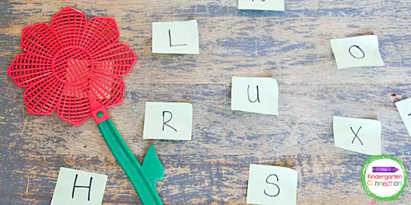 Flower-shaped flyswatter next to capital letters on sticky notes 