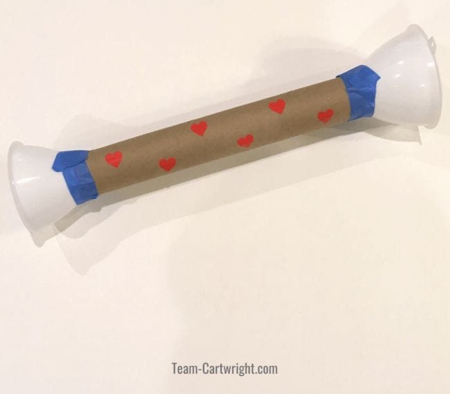Cardboard tube with plastic cups connected to the ends