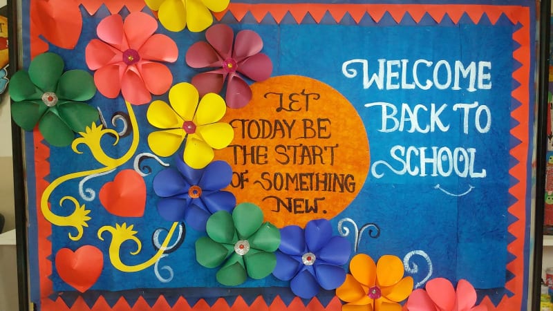 Welcome Back to School bulletin board with 3-D paper flowers. Text reads Let Today Be the Start of Something New.