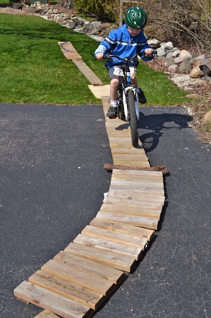 Child on bicycle riding on wood path