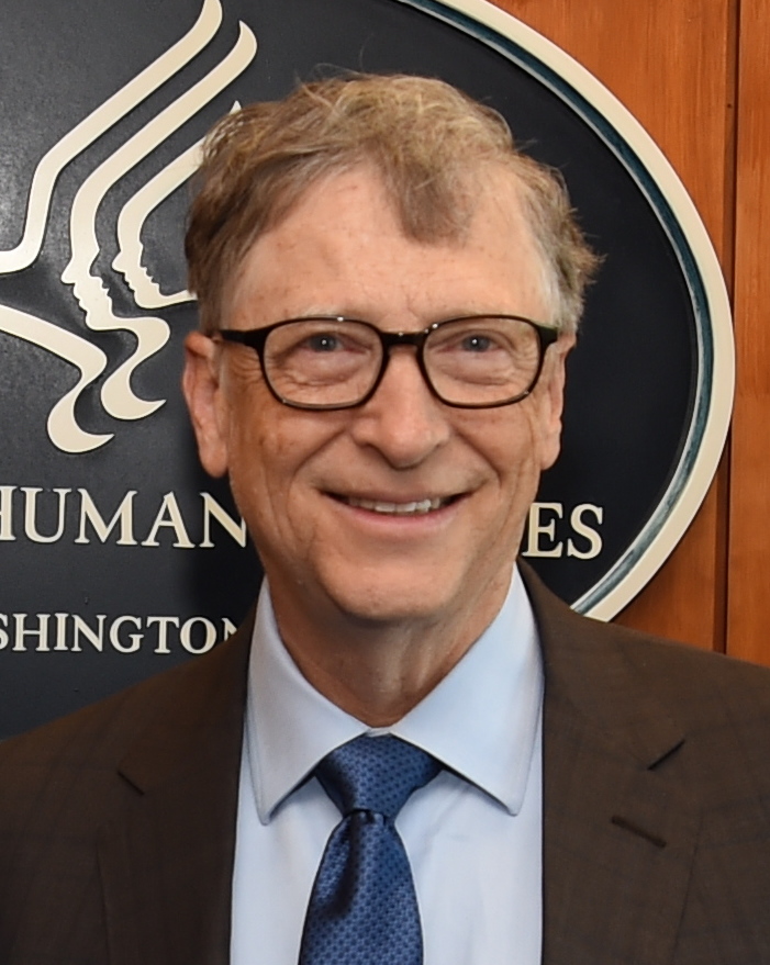An older man with glasses is seen looking head on at the camera smiling.