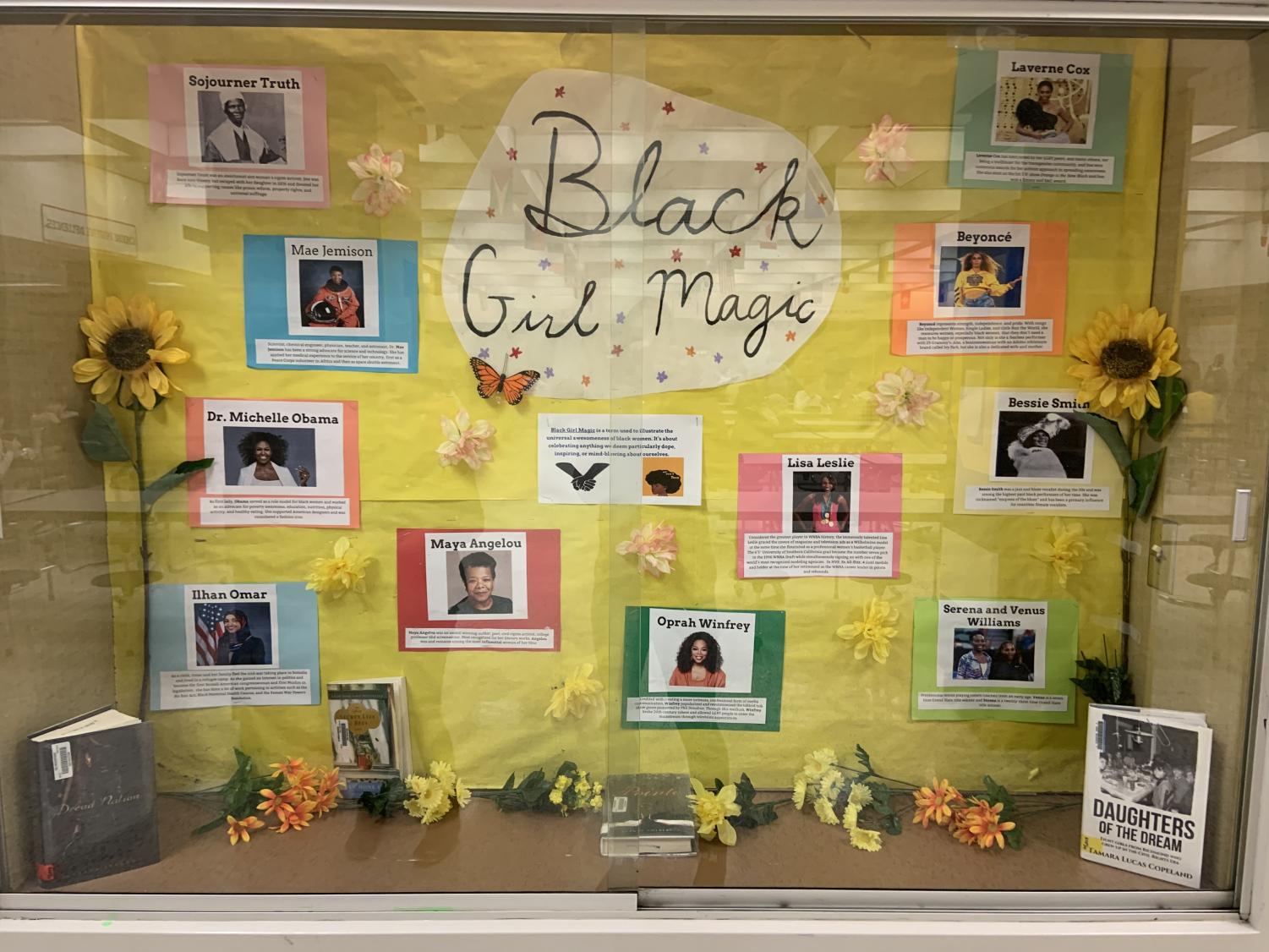 A yellow board has text that reads Black Girl Magic. It has photos and descriptions of famous Black women on it (black history month bulletin board)