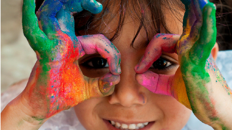Preschool girl with hands covered in colorful paint - Early Childhood Resources