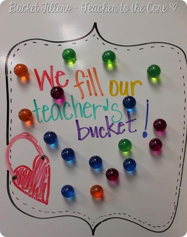 Colored magnets on a whiteboard with text reading We fill our teacher's bucket as an example of bucket filler activities