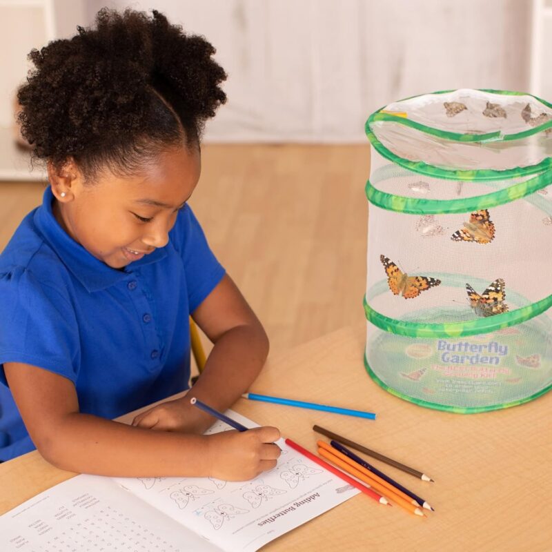 A little girl is seen writing observations in a journal. Beside her is a netted container with three monarch butterflies inside it in this example of very hungry caterpillar activities.