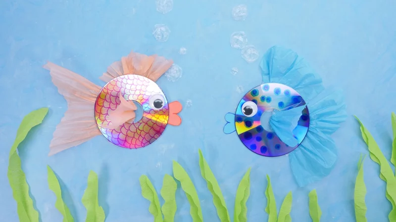 Two fish are made from CDs with eyes and tissue paper fins added.