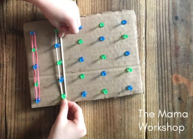 Cardboard with thumb tacks and string connected through the thumb tacks