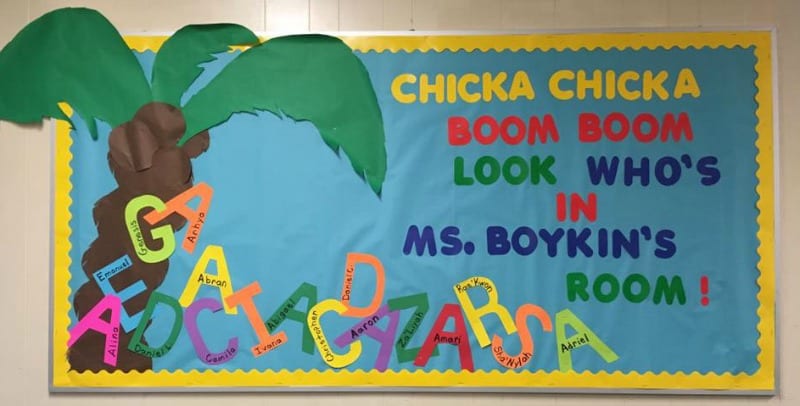 Bulletin board with large palm tree and alphabet letters with kids names written on them. Text reads Chicka Chicka Boom Boom Look Who's In Ms. Boykin's Room