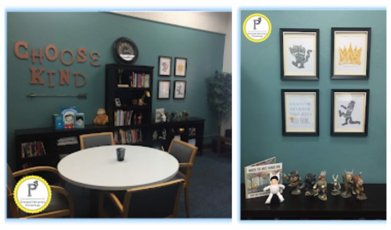 a principal's work space with a bright teal wall, table and chairs and a wall of bookcases. Also, four prints , action figures and the book Where the Wild Things Are