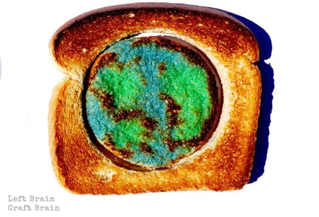 Piece of toast with center section cut out and milk painted to resemble Earth (Climate Change Activities)