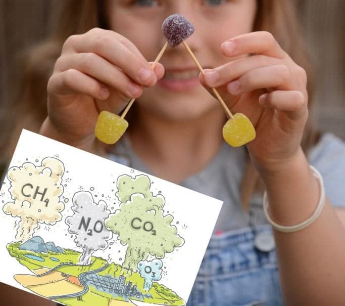 Student's hands holding a water vapor model made of toothpicks and gumdrops (Climate Change)