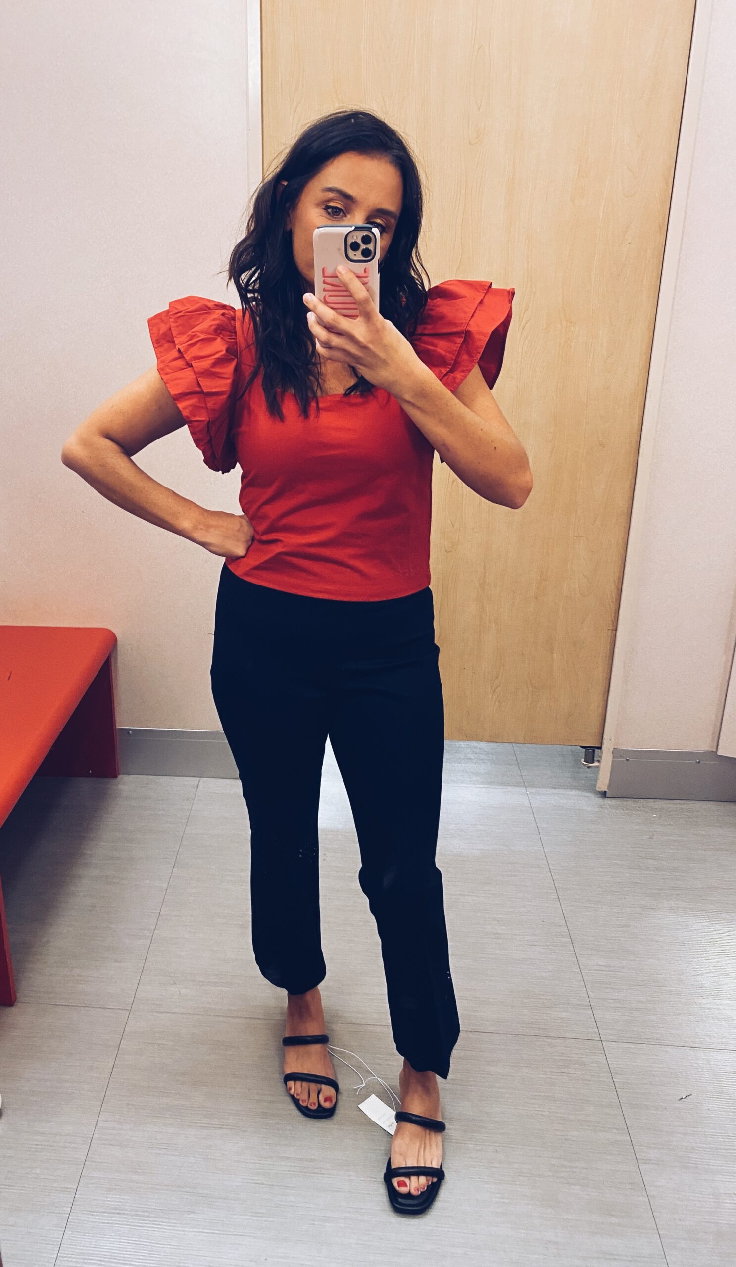 Woman wearing black pants and ruffle shirt as an example of cute teacher outfits