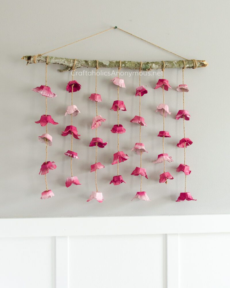 art auction ideas- kid made wall hanging with egg carton flower petals dangling from a branch 