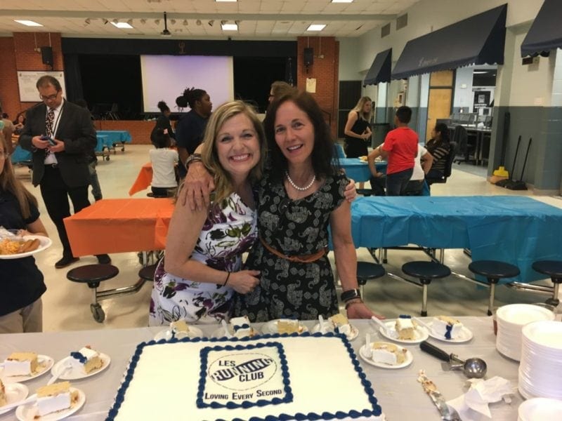 Two teachers cutting a cake who advocate for student physical activity