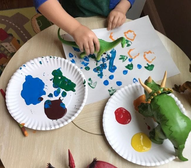 Dinosaur toys used as paintbrush on paper