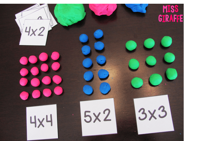 Colorful balls of play dough laid out in arrays above multiplication problems 