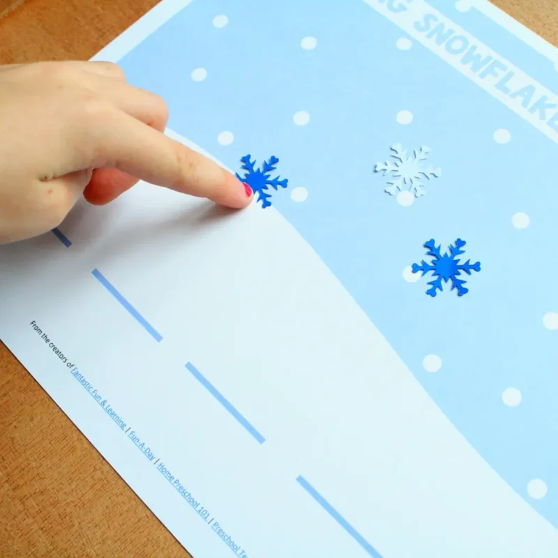 finger moving a snowflake from sky into one of the a blank sound spaces, as an example of reading activities