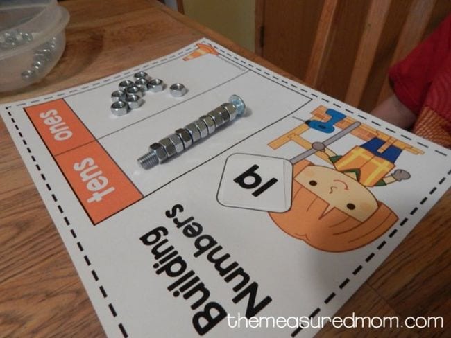 Building Numbers worksheet with picture of child in construction gear and nuts and bolts used to represent tens and ones