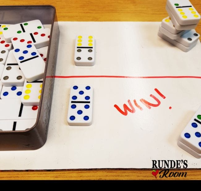 a bin of colored dominoes on top of a white board with the words win! written on it